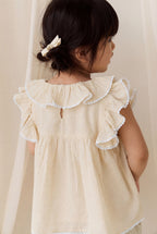 Chemisier délicat en coton biologique couleur parchemin, avec manches volantées et col à volants pour filles de 0 à 10 ans