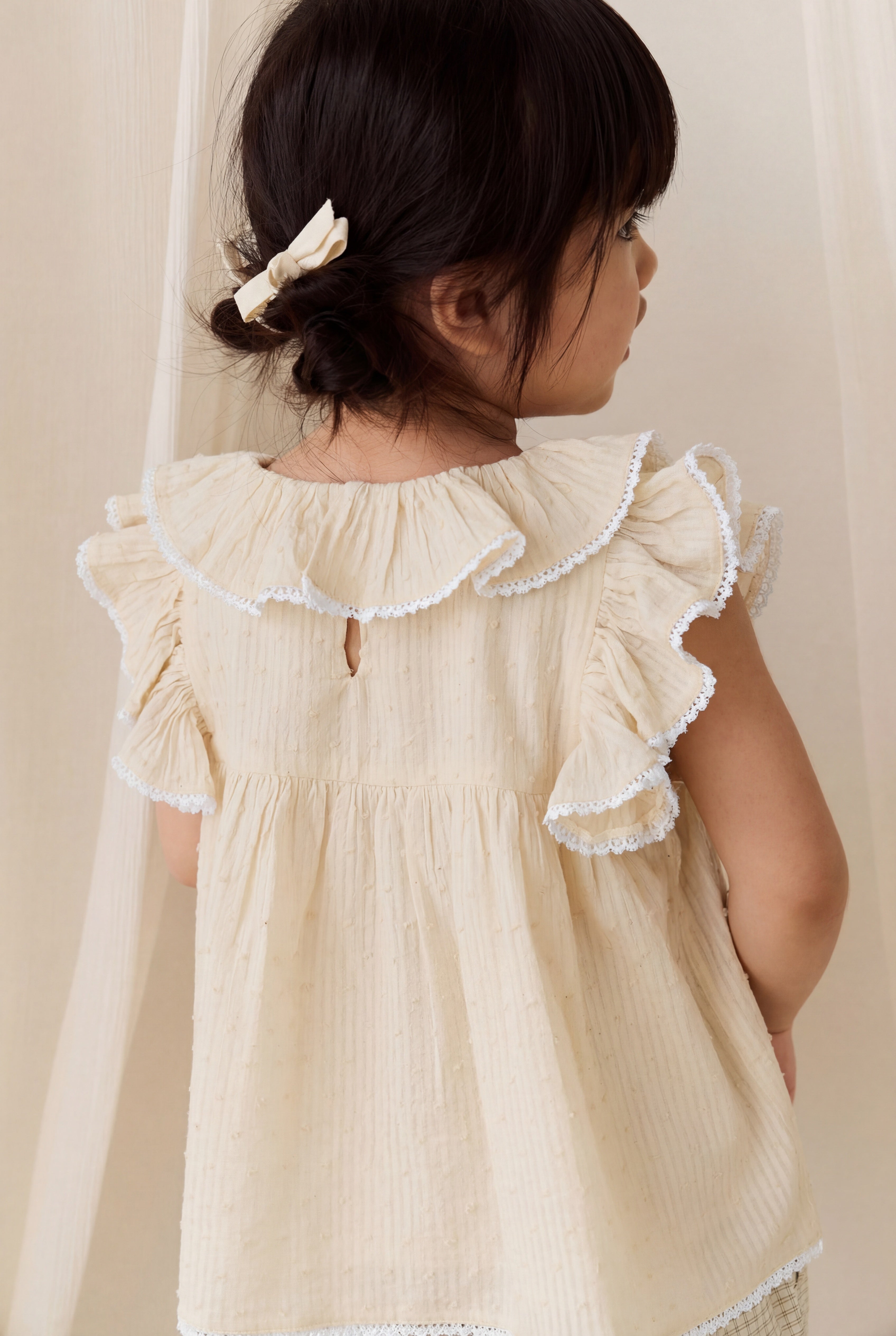 Chemisier délicat en coton biologique couleur parchemin, avec manches volantées et col à volants pour filles de 0 à 10 ans